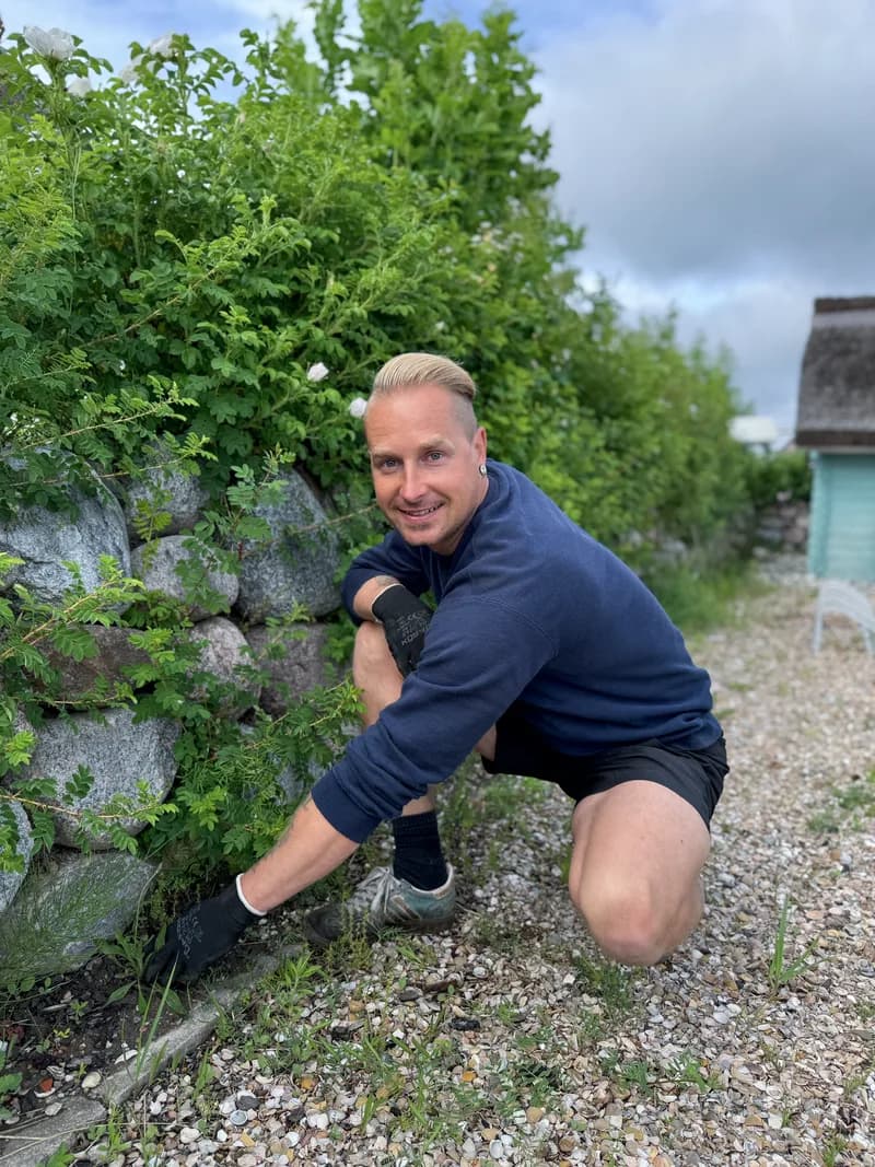 Martin Zühl bei der Gartenpflege vor einer Natursteinmauer – Zühl Hausmeister- & Handwerksservice Stralsund